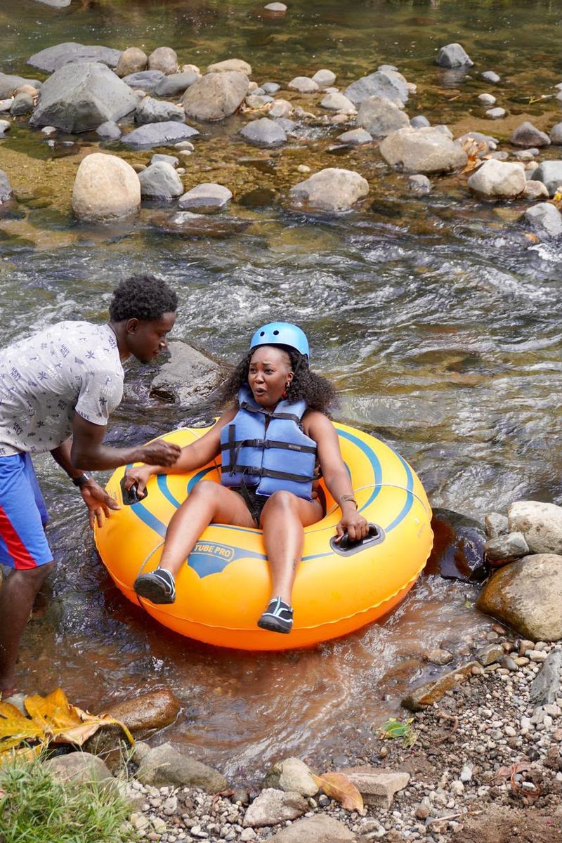 A guide helping a guest into a river tube