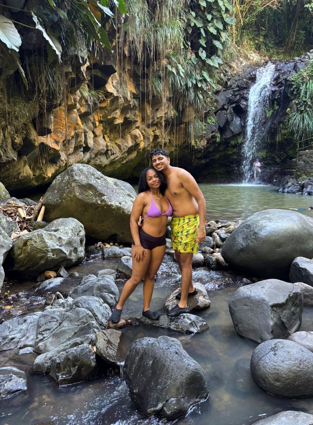 Two guests in the stream below the waterfall