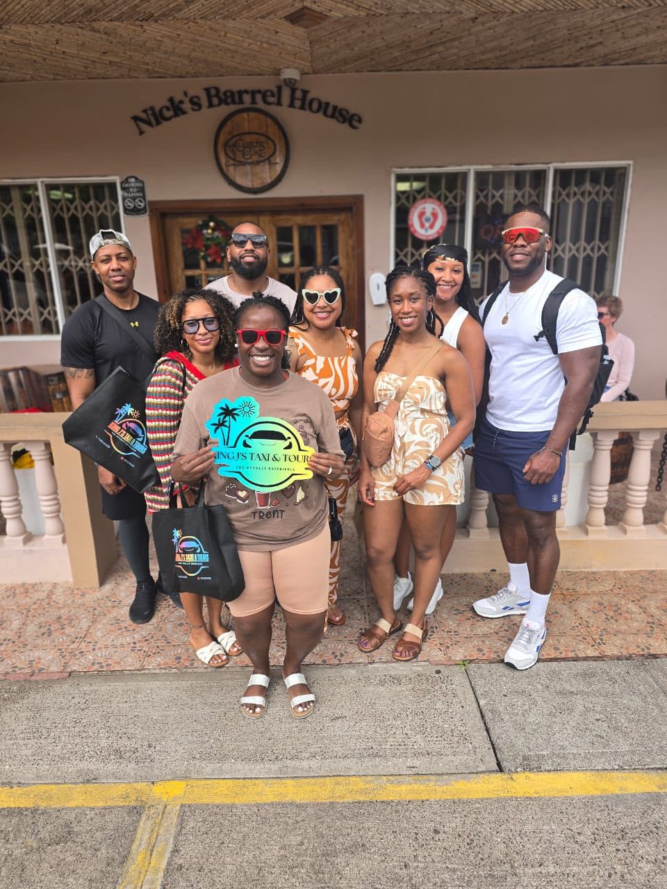 A group outside Nick’s Barrel House with the King J’s sign